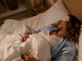 a woman sleeping with a pink sleep mask